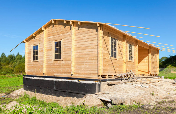 Construction of a new wooden house in summer sunny day - Photo, Image
