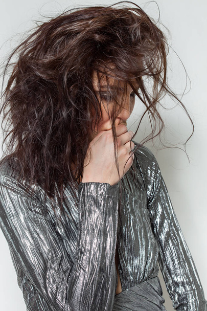 Thoughtful woman portrait with messy hair wearing silver dress - Photo, Image