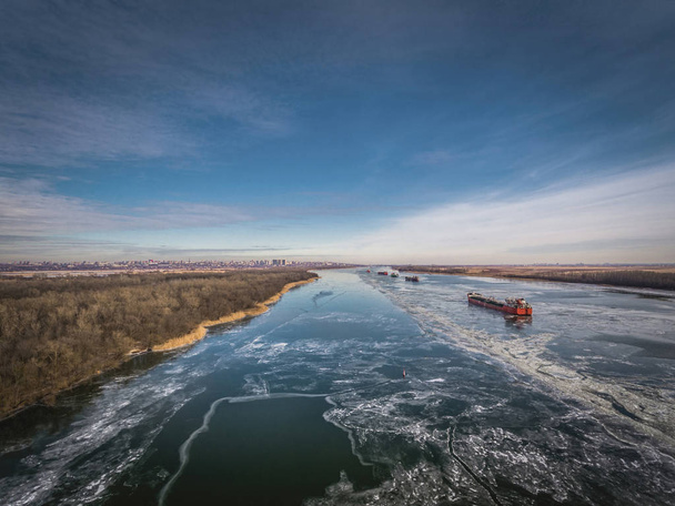 Cargo ship on the ice river in winter. - Fotoğraf, Görsel