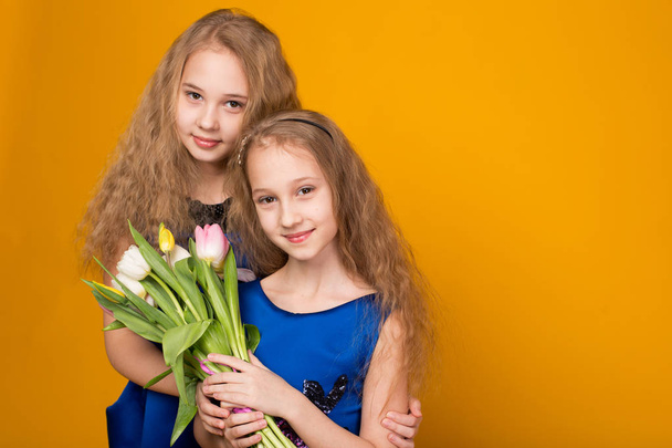 Two beautiful young girl with a bouquet of flowers - 写真・画像