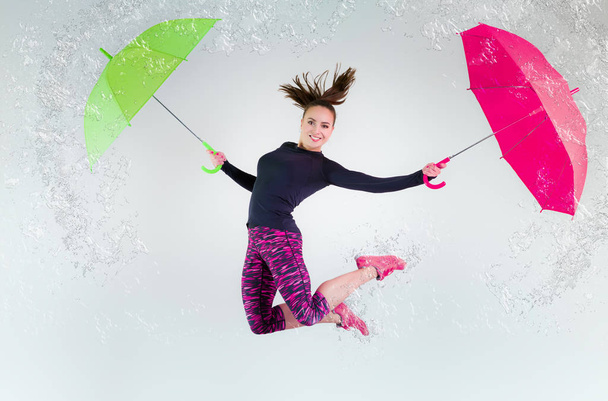 Woman in jump with an umbrella. Frozen motion. - 写真・画像
