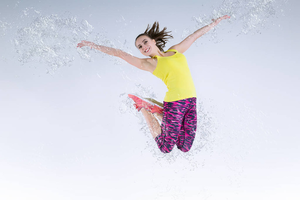 Woman in jump. Frozen motion. Photo manipulation splashing water - Foto, Imagem