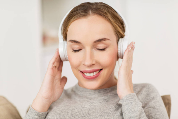 kobieta ze słuchawkami słuchająca muzyki w domu - Zdjęcie, obraz