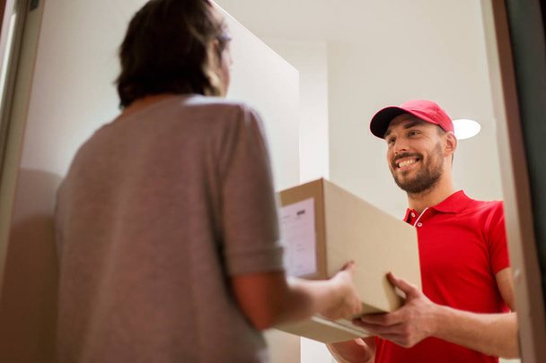 happy delivery man giving parcel box to customer - Fotoğraf, Görsel