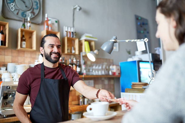man or waiter serving customer at coffee shop - Фото, зображення