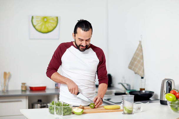 man with blender and fruit cooking at home kitchen - Fotografie, Obrázek