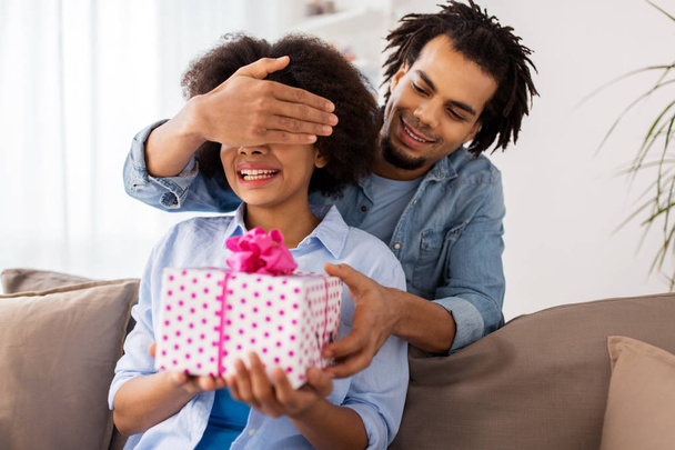 happy couple with gift box at home - Foto, afbeelding