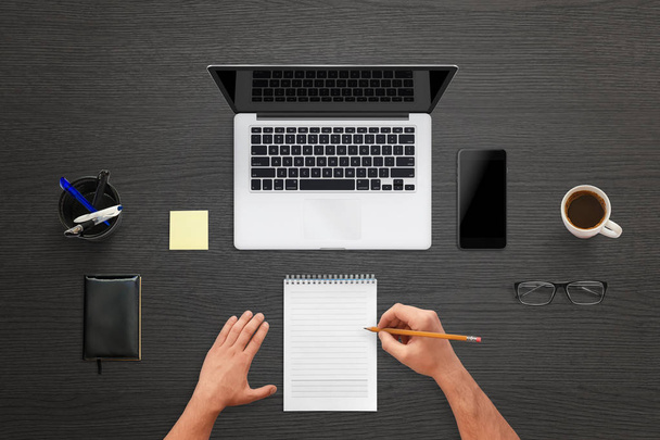 Człowiek pisać na klawiaturze. Widok góry biurko z laptopa, telefon komórkowy z pusty ekran dla makieta - Zdjęcie, obraz