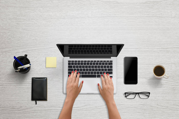 Woman tap on laptop keyboard. Blank screen for mockup, design presentation. Modern office scene with black smart phone beside - Photo, Image