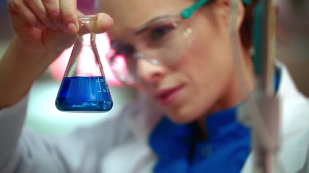 Female scientist mixing chemical liquid in lab flask. Scientist cure research - Séquence, vidéo