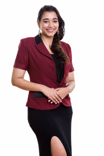 Студийный снимок молодой счастливой индийской бизнес-леди, улыбающейся стоя - Фото, изображение
