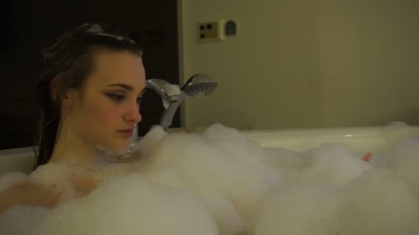 attractive young woman bathed in the hot tub with foam - Filmati, video