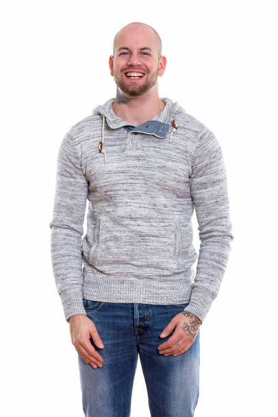 Studio shot of young happy bald muscular man smiling while standing - Photo, Image