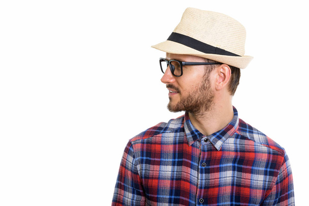 Profil widok szczęśliwy młody człowiek uśmiechnięty podczas noszenia kapelusza i okularów - Zdjęcie, obraz