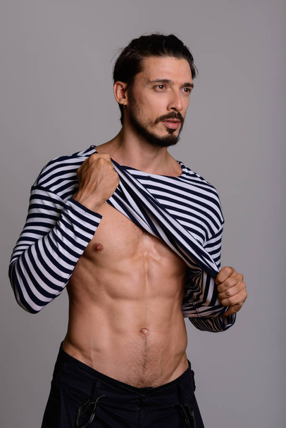 Studio shot of handsome man showing abs and thinking - Foto, immagini