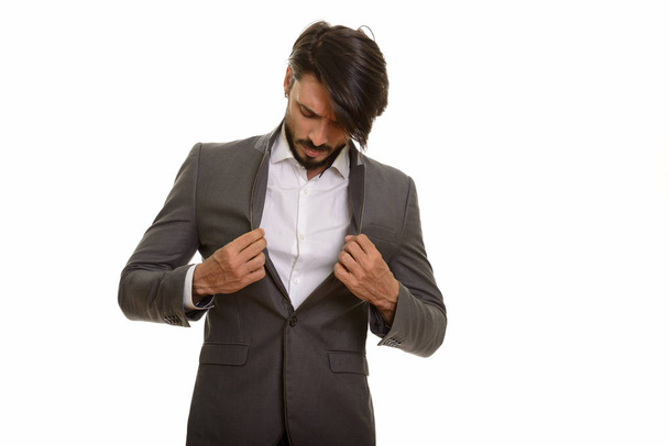 Studio shot of handsome businessman checking jacket - Foto, imagen