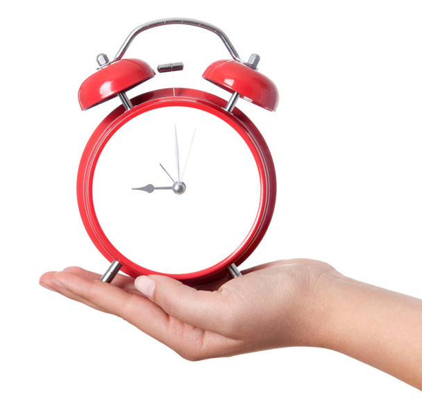 Closeup shot of a woman holding red heartshape alarm clock. Clos - Photo, Image