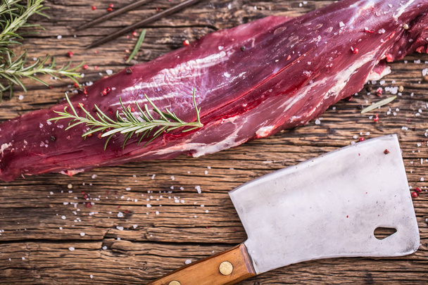 Raw beef tenderloin steak on a cutting board with rosemary pepper salt in other positions - Φωτογραφία, εικόνα