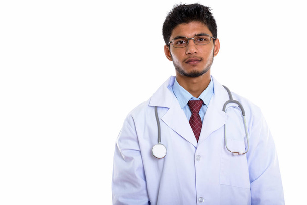 Studio shot of young handsome Indian man doctor - Foto, Imagem