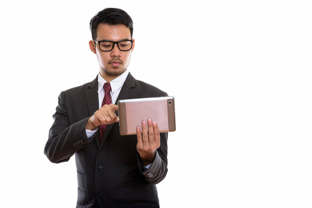 Studioaufnahme eines jungen asiatischen Geschäftsmannes mit digitalem Tablet - Foto, Bild