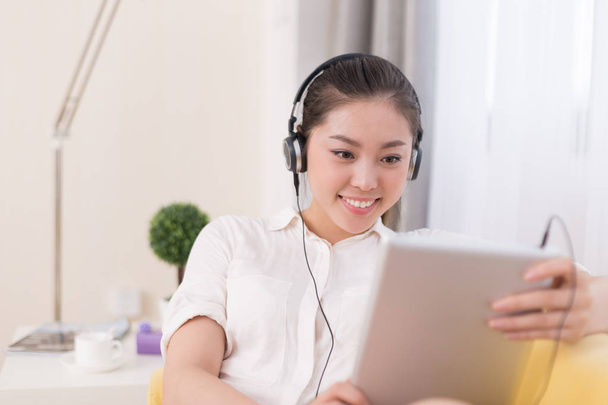 Kiinalainen nainen kuuntelee musiikkia huoneessa
 - Valokuva, kuva