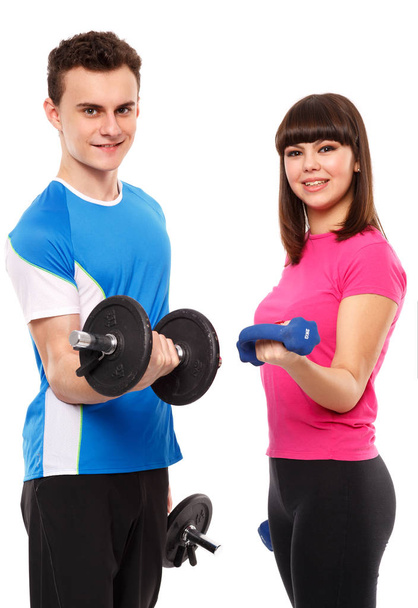 Teenage couple exercising with dumbbells - Фото, изображение