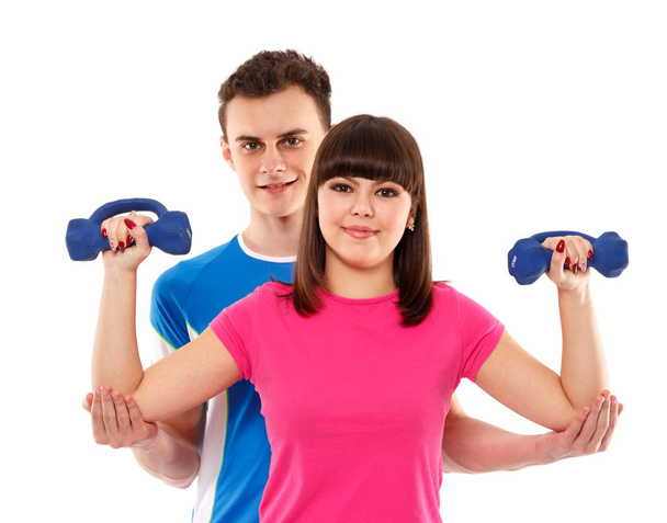 Teenage couple exercising with dumbbells - 写真・画像