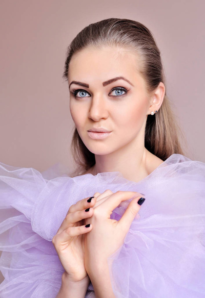 Portrét mladé krásné ženy ve světle fialový závoj - Fotografie, Obrázek