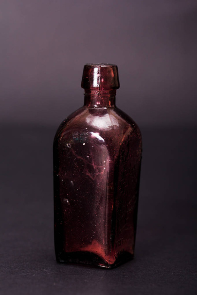 Old colourful bottles against a dark background - Foto, Imagen