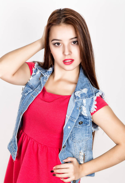 beautiful young woman dressed in a red dress holding a lollipop, studio shot - Foto, Imagem