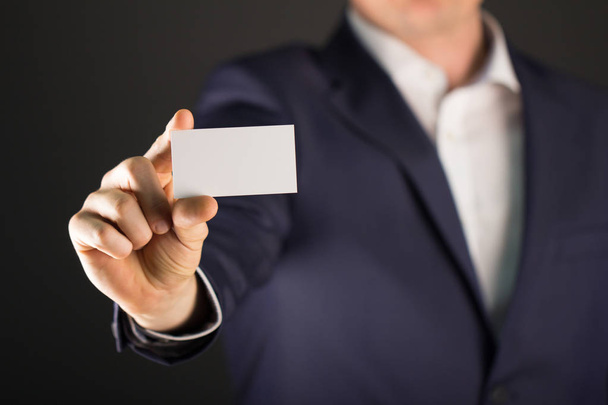 空白の buissnes カードを持っているスーツのビジネスマン - 写真・画像