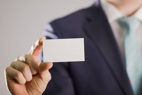 Empresario de traje con una tarjeta de buissnes en blanco
 - Foto, Imagen