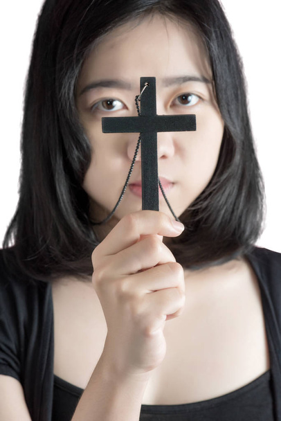 Mujer asiática hermosa con la celebración esperanzadora símbolo cristiano de crucifijo orando a Dios aislado sobre fondo blanco. Recorte de ruta sobre fondo blanco
. - Foto, imagen