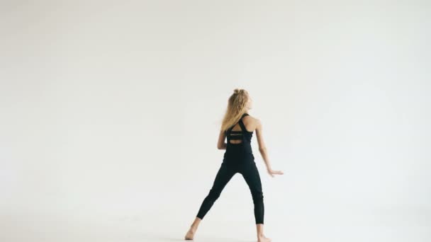 Modern beautiful teenage girl dancer dancing contemporary on white background indoors - Filmagem, Vídeo