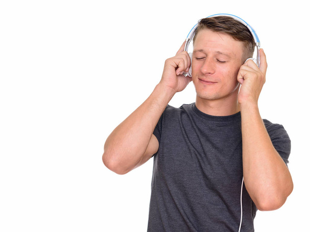 Studio laukaus nuori komea valkoihoinen mies kuuntelee musiikkia i
 - Valokuva, kuva