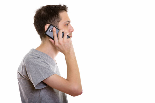 Hossz-szelvény nézet fiatalember mobiltelefonján beszél - Fotó, kép
