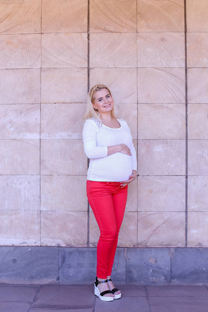 Carino giovane donna incinta delicatamente toccando pancia e posa in
 - Foto, immagini
