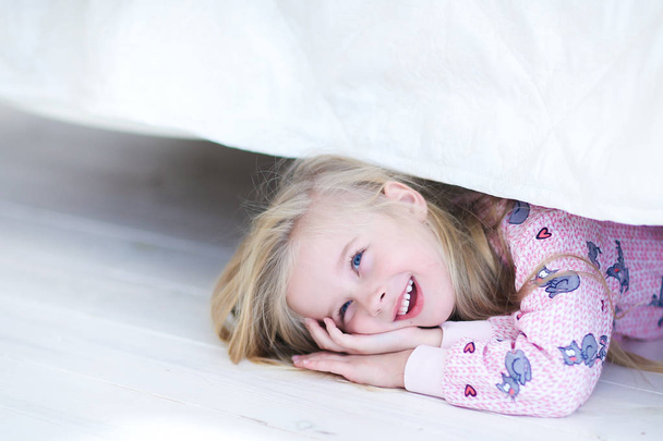 Tochter versteckt sich unter Bett, Mutter und Vater sprechen zu Hause - Foto, Bild