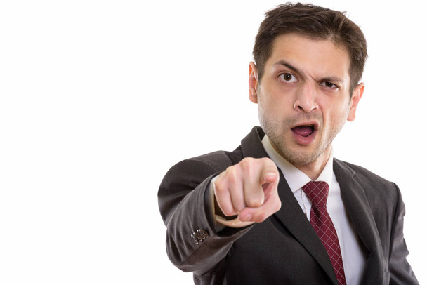 Studio shot of angry young businessman pointing at camera  - Photo, Image