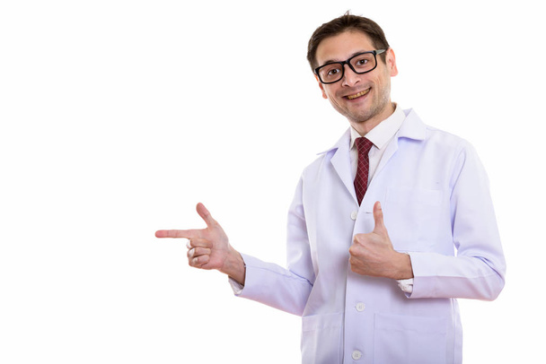 Студійний знімок щасливого молодого чоловіка лікар посміхається, вказуючи на
  - Фото, зображення