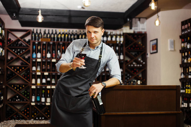 Male sommelier tasting red wine in cellar. Professional degustation expert - Valokuva, kuva
