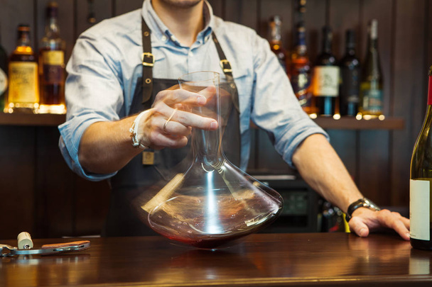 Bartender decanting wine without disturbing the sediment - Photo, image