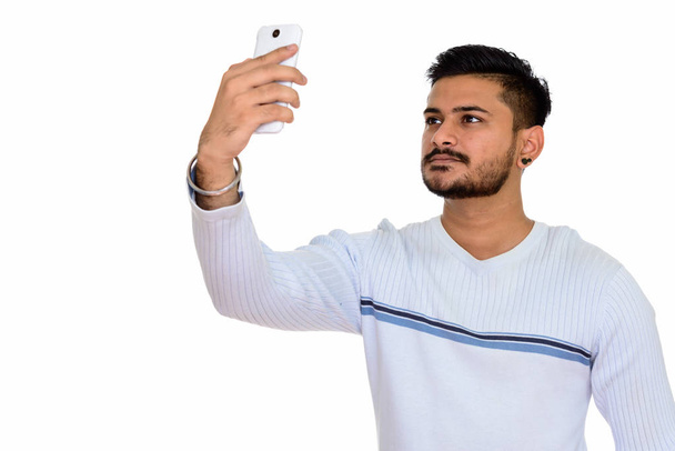 Young handsome Indian man taking selfie with mobile phone - Photo, Image