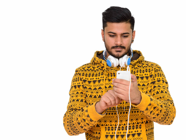 Mladý hezký kostým Indián používající mobilní telefon se sluchátky - Fotografie, Obrázek