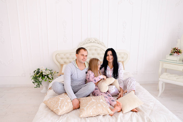 Retrato feliz familia en pijama sonriendo y mirando a la cámara i
 - Foto, imagen