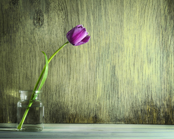 Spring tulips in a glass jar on a wooden background - Zdjęcie, obraz