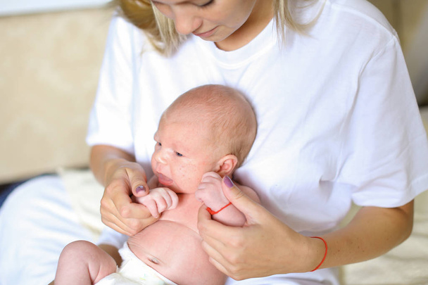 Hermosa hembra sosteniendo en las manos recién nacido y abrazos, sonrisas y c
 - Foto, Imagen