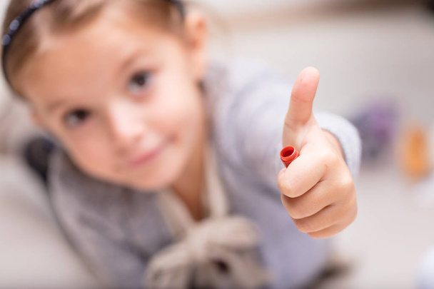 Little girl giving a thumbs up sign - 写真・画像