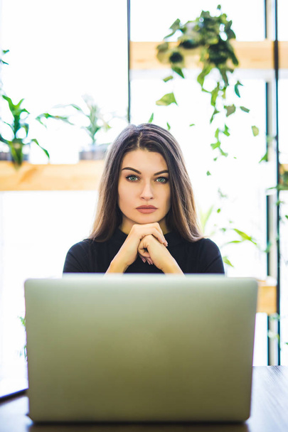Retrato de mulher de negócios atraente sentado em chait e trabalhando no laptop online
. - Foto, Imagem