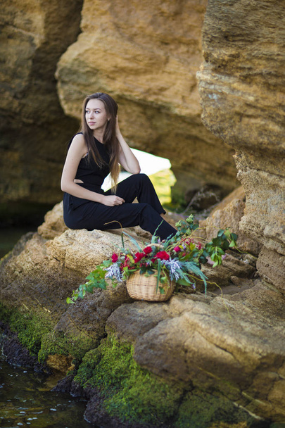 Portret van mooie jonge vrouw met bloemen op achtergrond sto - Foto, afbeelding